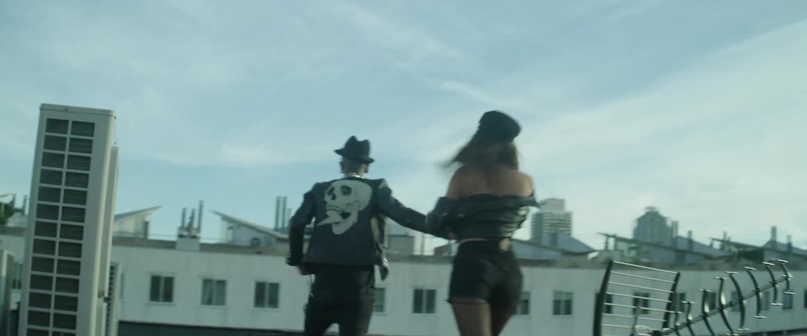A man and woman run on the roof top