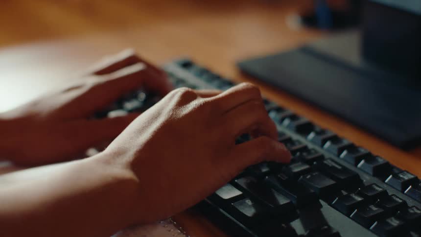 Closeup of a womans hands using a keyboard and mouse
