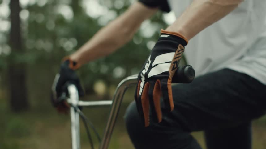 A man gripping bicycle handlebars outdoors