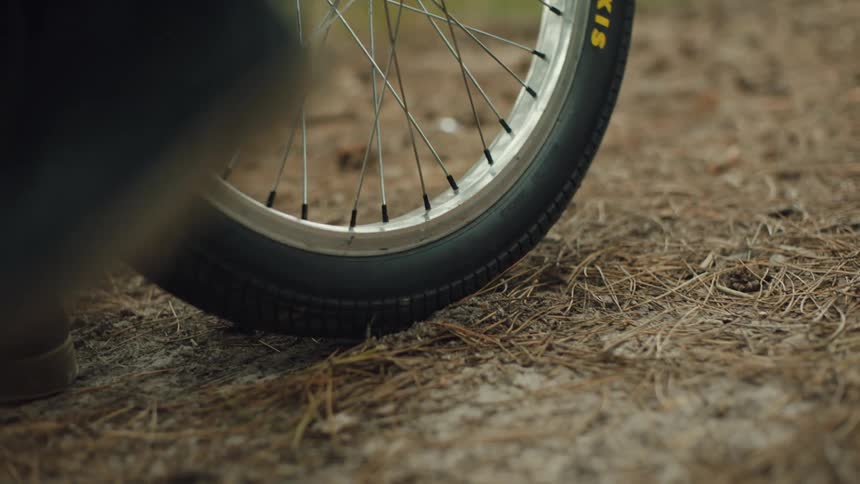 A person rolls the wheel of his bicycle