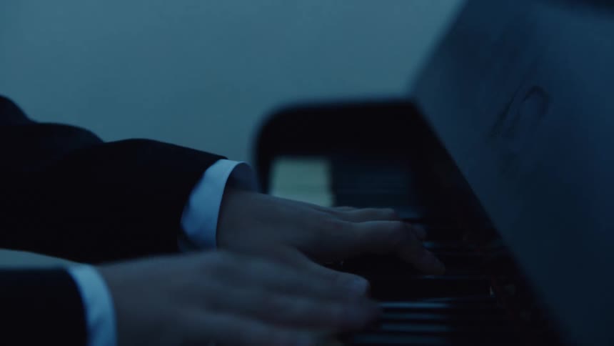 A close up of a mans hands playing the piano outdoors