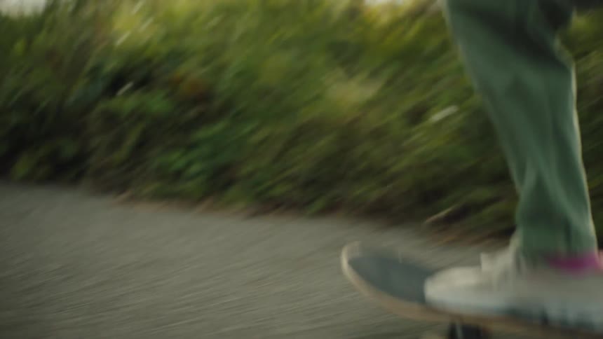 Two people skateboarding on a paved road