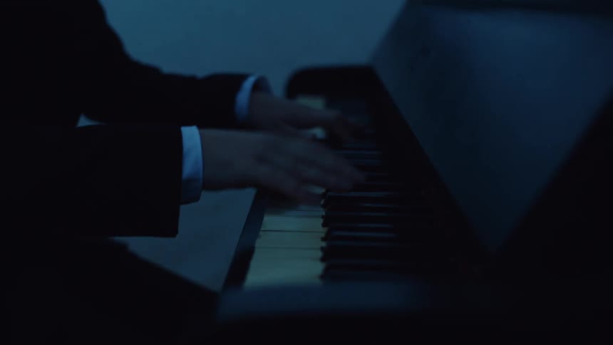 A man is playing the piano by the water