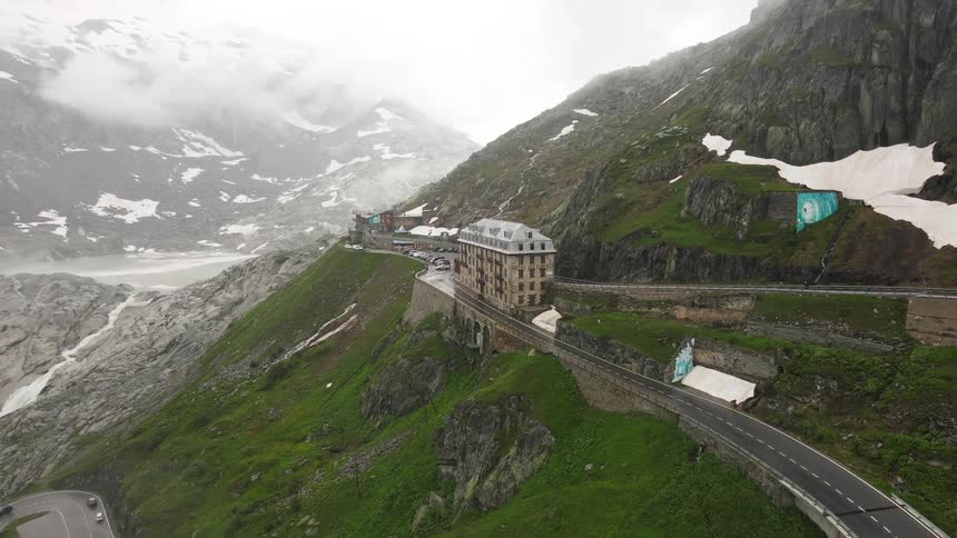 A hotel between two converging roads on the side of a mountain