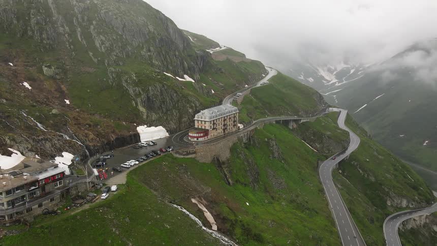 Aerial panorama of winding streets in snowy mountains and buildings on a cloudy day