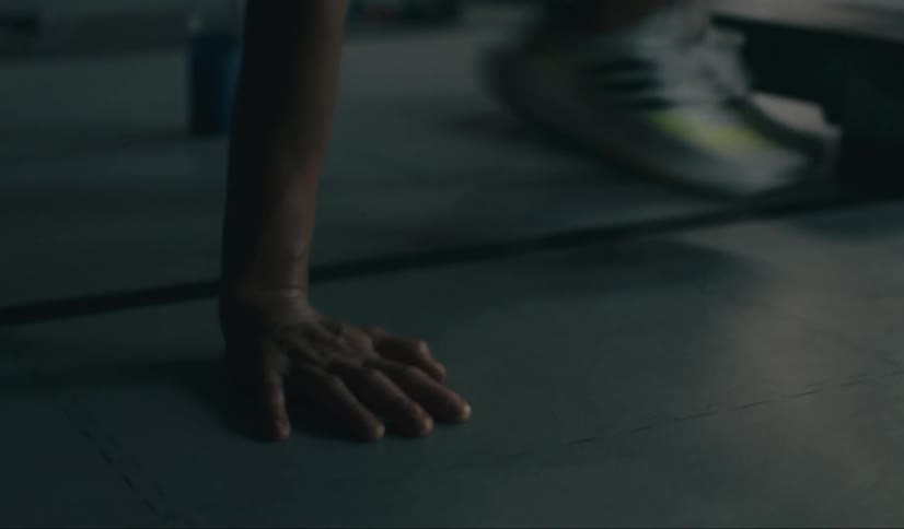 Woman gets up from the floor of a gym and rebalances herself in her shoes