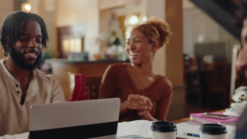 Friends sitting at a table smiling and talking