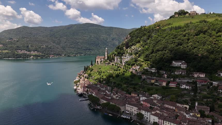 Aerial view of houses built on a green mountain by the sea