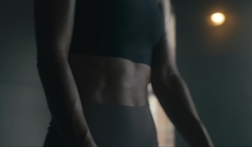 A woman wearing tight fitting clothing runs her hands over her hips