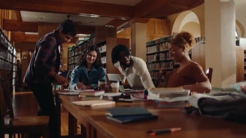 A group of individuals sitting at a long table engaged in a study session