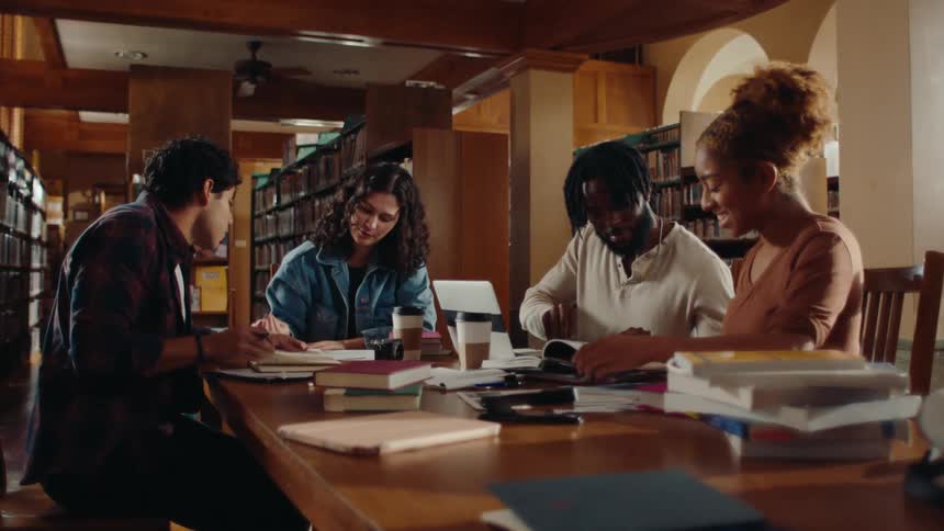 A group of students are studying together while sitting in a school library