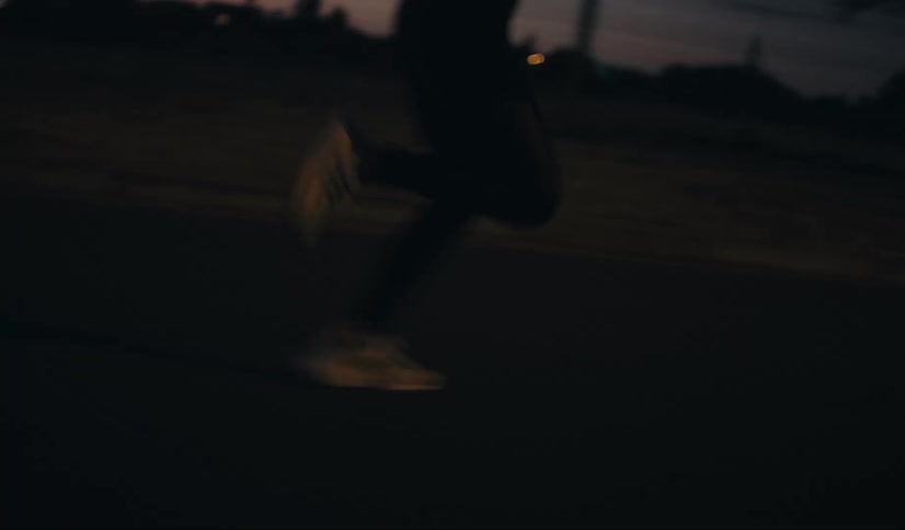A person runs down the road at night
