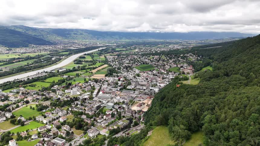 Aerial panorama of an urban city around a mountain and on the edge of a river canal