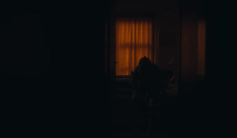 Silhouette of a person getting up from bed in a dark room at night