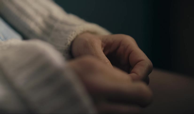 The hands of a person who is moving their fingers together and she has the sleeves of a long white shirt