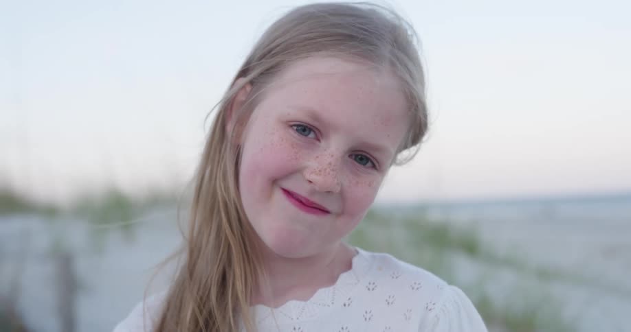 Portrait of a happy young blonde girl at the beach