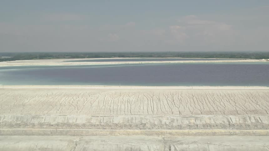 Aerial view of white dirt and blue wastewater ponds