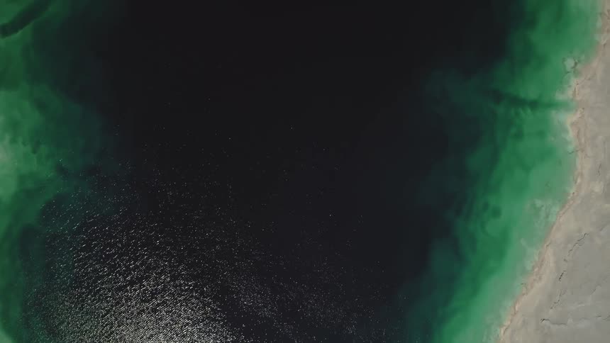 Top down view of blue green industrial tailings pond