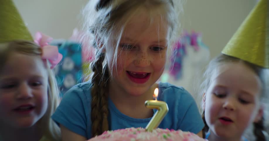 A child gets ready to blow out a birthday candle