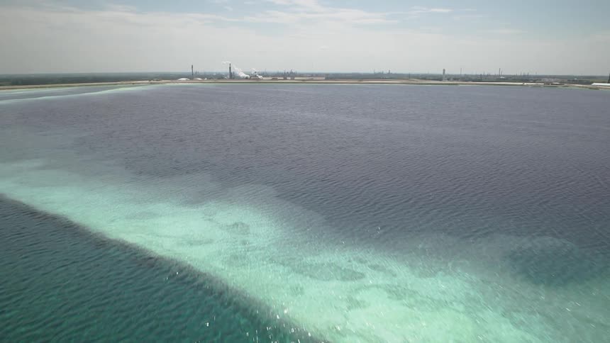 Rippling transparent blue industrial wastewater flyover in front of a chemical plant