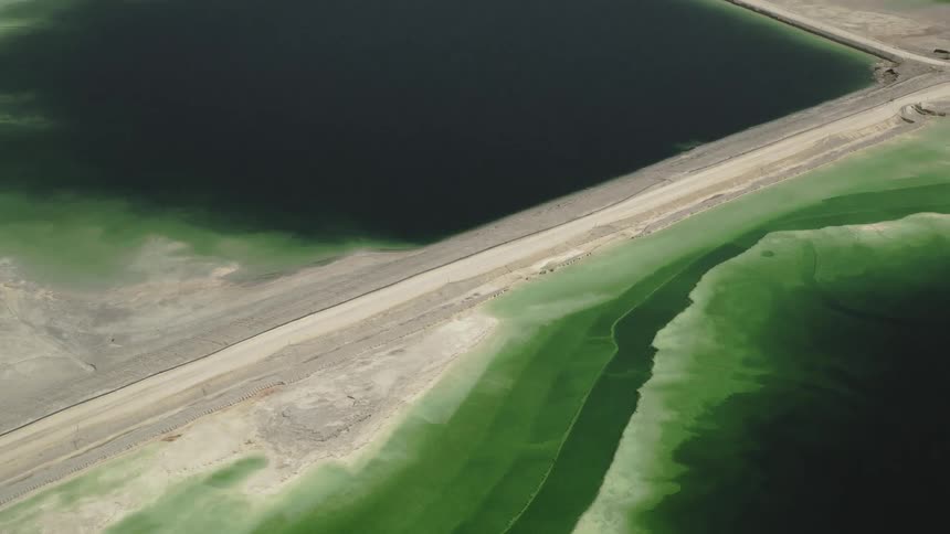 Two large industrial reservoirs of different shades of green
