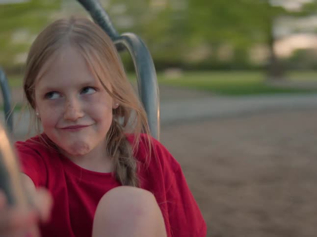 Portrait of a small blonde child on a toy that is spinning