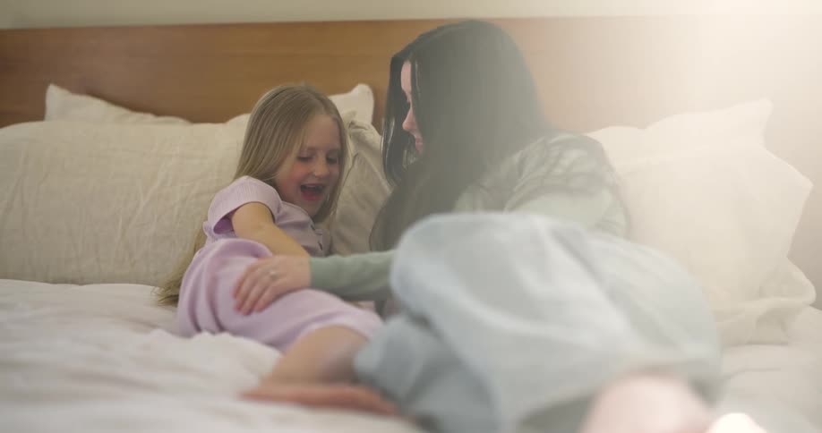 Mother lying in bed with her daughter talking