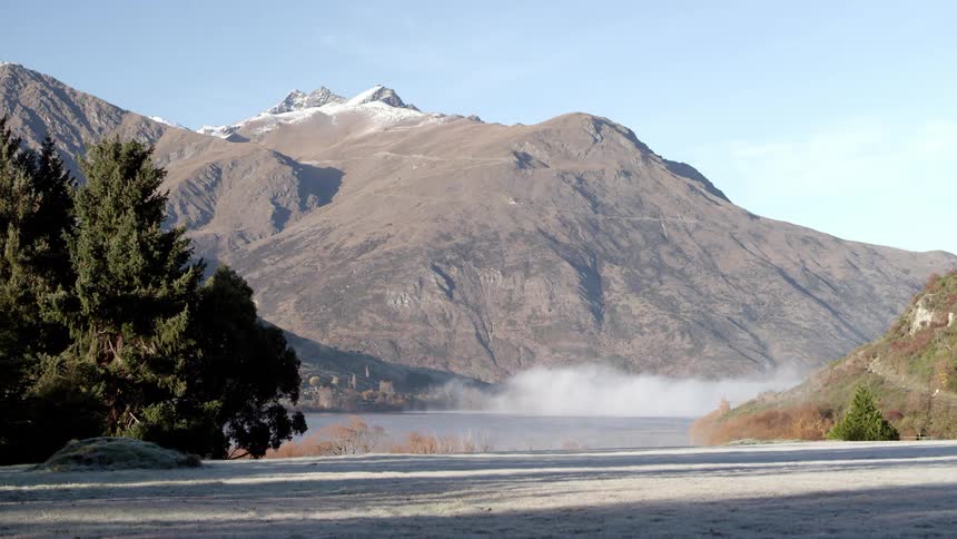 Majestic mountain range with snowcapped peaks and a serene lake below