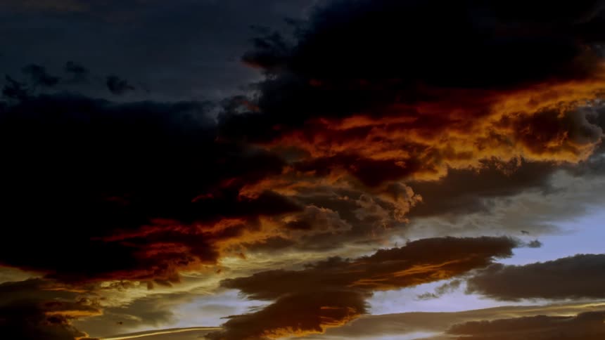 A dramatic sky with dark clouds and vibrant orange hues