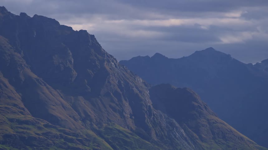 Mountain landscape with peaks and steep slopes under a cloudy sky