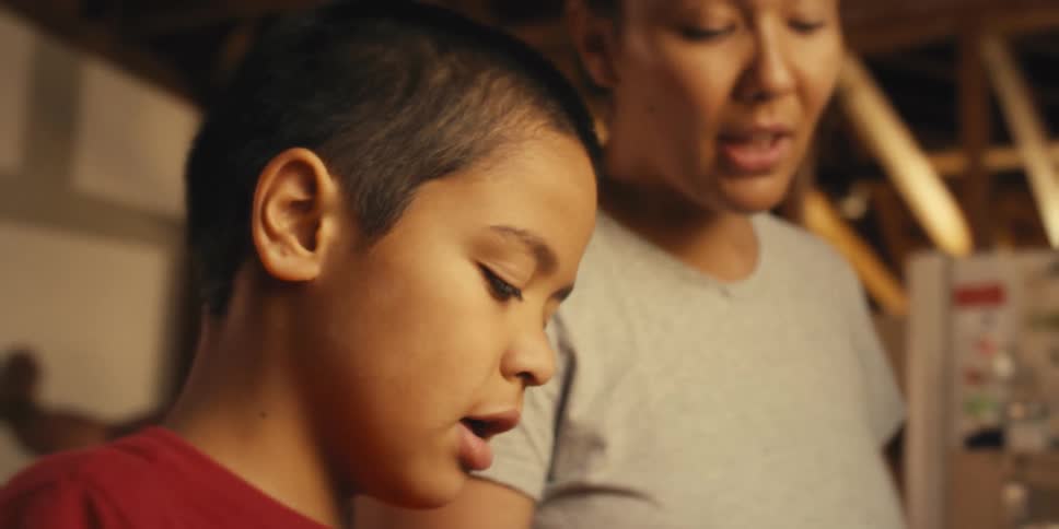 Young boy helping his mother prepare food