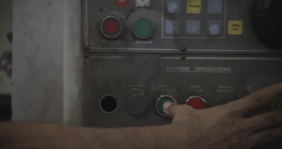 A man presses buttons on a control panel