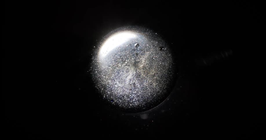 A glowing bubble with movement inside it and it is on a completely dark background