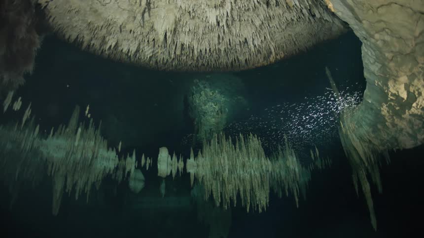 An underwater view of a cave with impressive stalactites