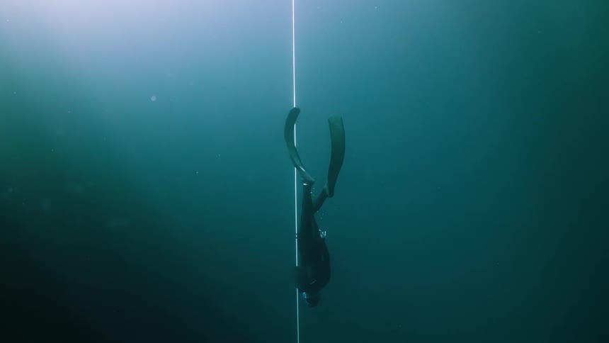 Diver in the ocean going to the bottom
