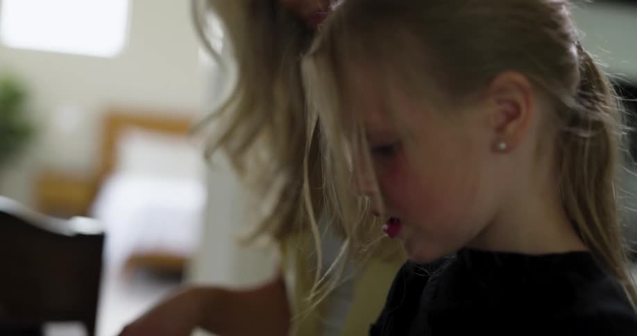 A mother and her daughter practicing piano in a room