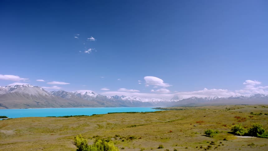 Landscape of a blue lake surrounded by snowy mountains