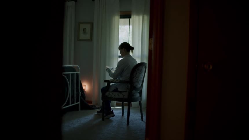 Woman sitting on a chair in the living room holding a picture frame