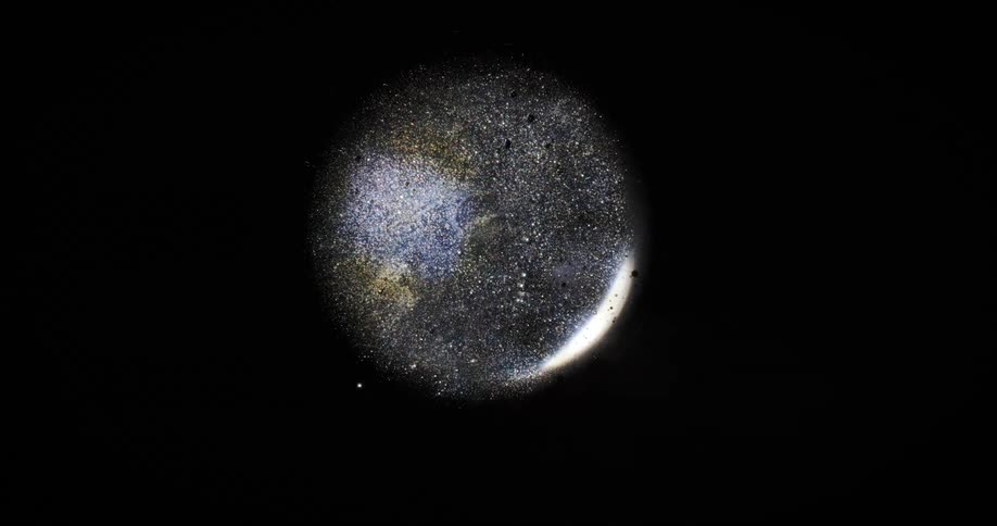 Extreme close up of an abstract water droplet with bubbles inside against a black background