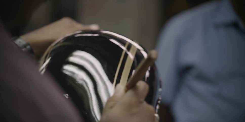 A man paints a stripe on a piece of painted metal