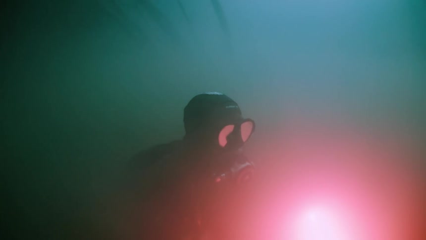 A diver exploring underwater with a bright flashlight