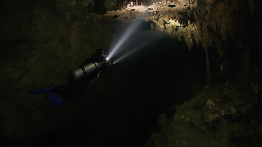 Diver inside a cave submerged in water
