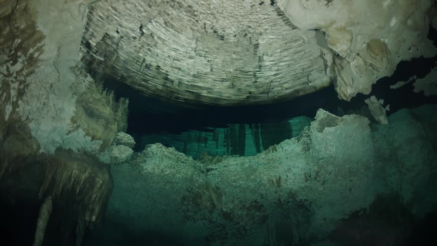 Interior of a cave with stalactites and a greenishblue glow