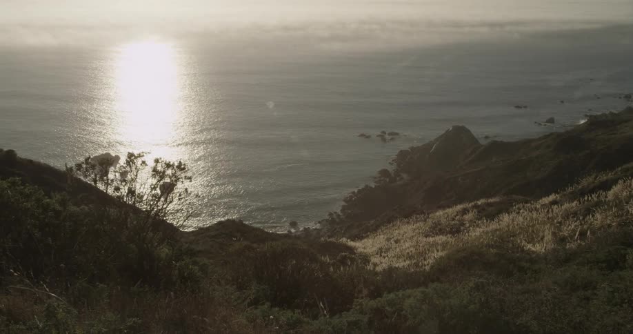 Shiny sunset reflecting off the ocean water as seen from land