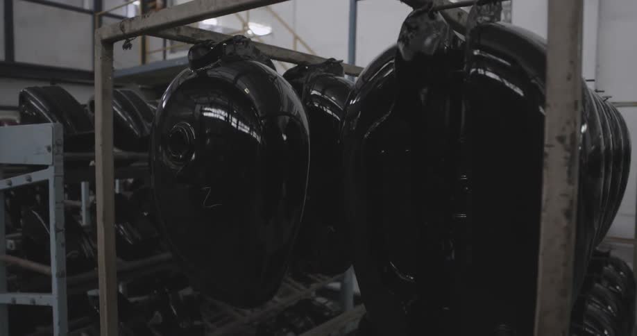 Motorcycle gas tanks hanging in a factory where they have just been made