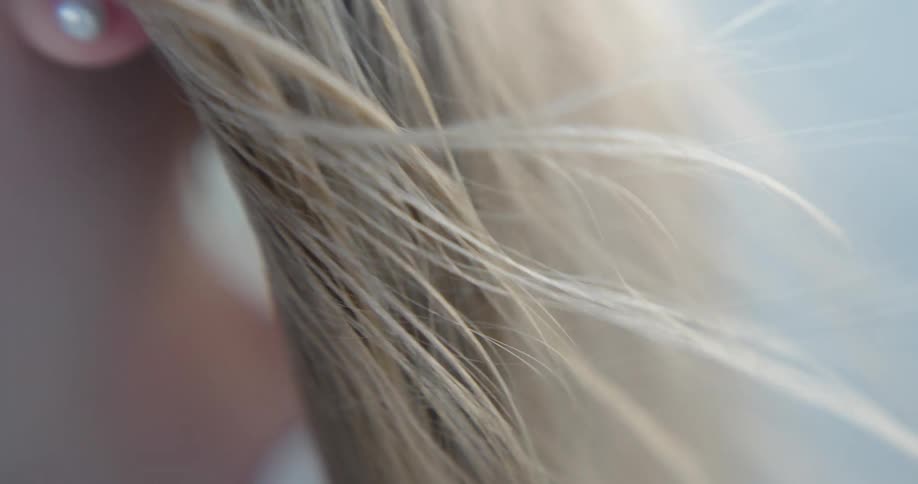 Hair of a blonde girl with an earring