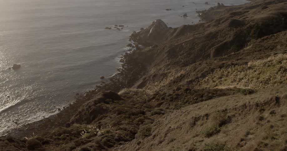 Waves crash against the shore below