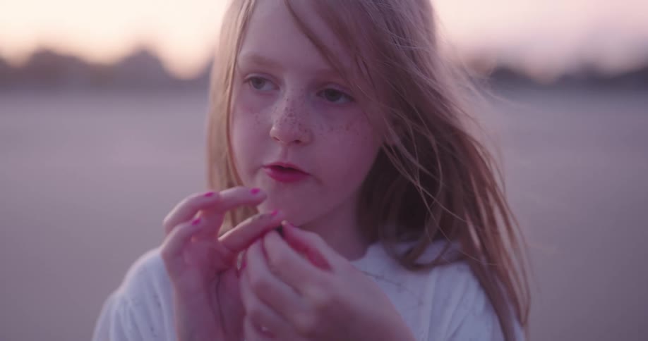 A young girl kisses a baby hermit crab