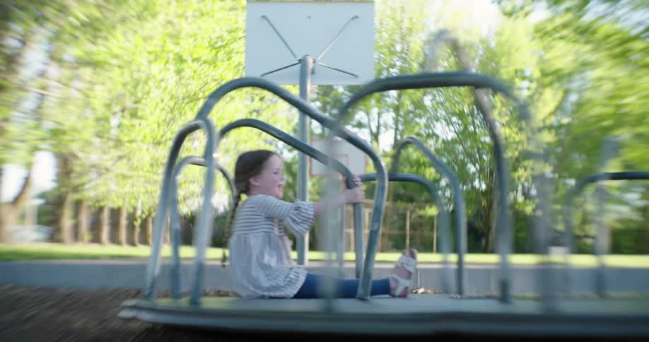 Video of a girl running and playing on playground equipment