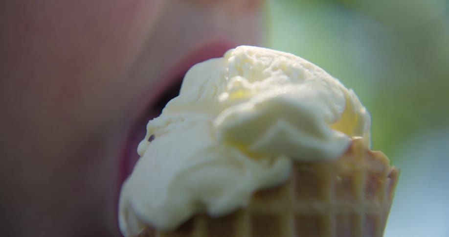 Mouth of a child eating vanilla ice cream